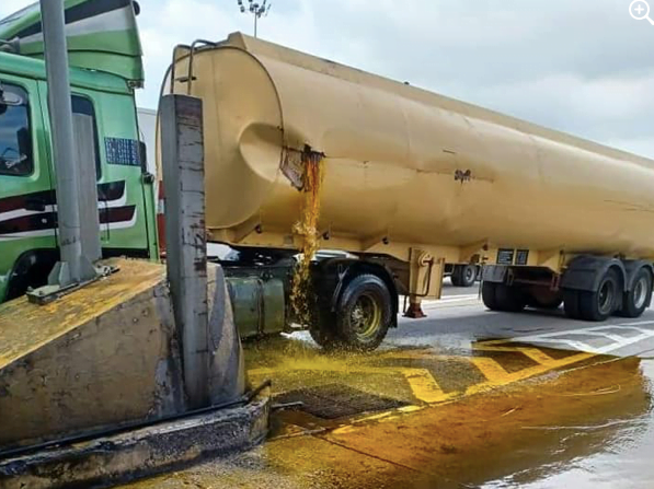 Kelihatan sebuah lori tangki membawa muatan minyak sawit bocor akibat terlanggar penghadang besi di Plaza Tol Juru, Pulau Pinang