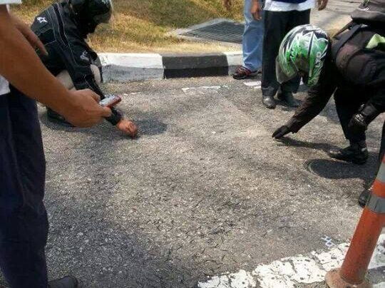 Kelihatan beberapa penunggang motosikal mengutip paku di jalan raya berhampiran Plaza Tol Sungai Besi, Kuala Lumpur
